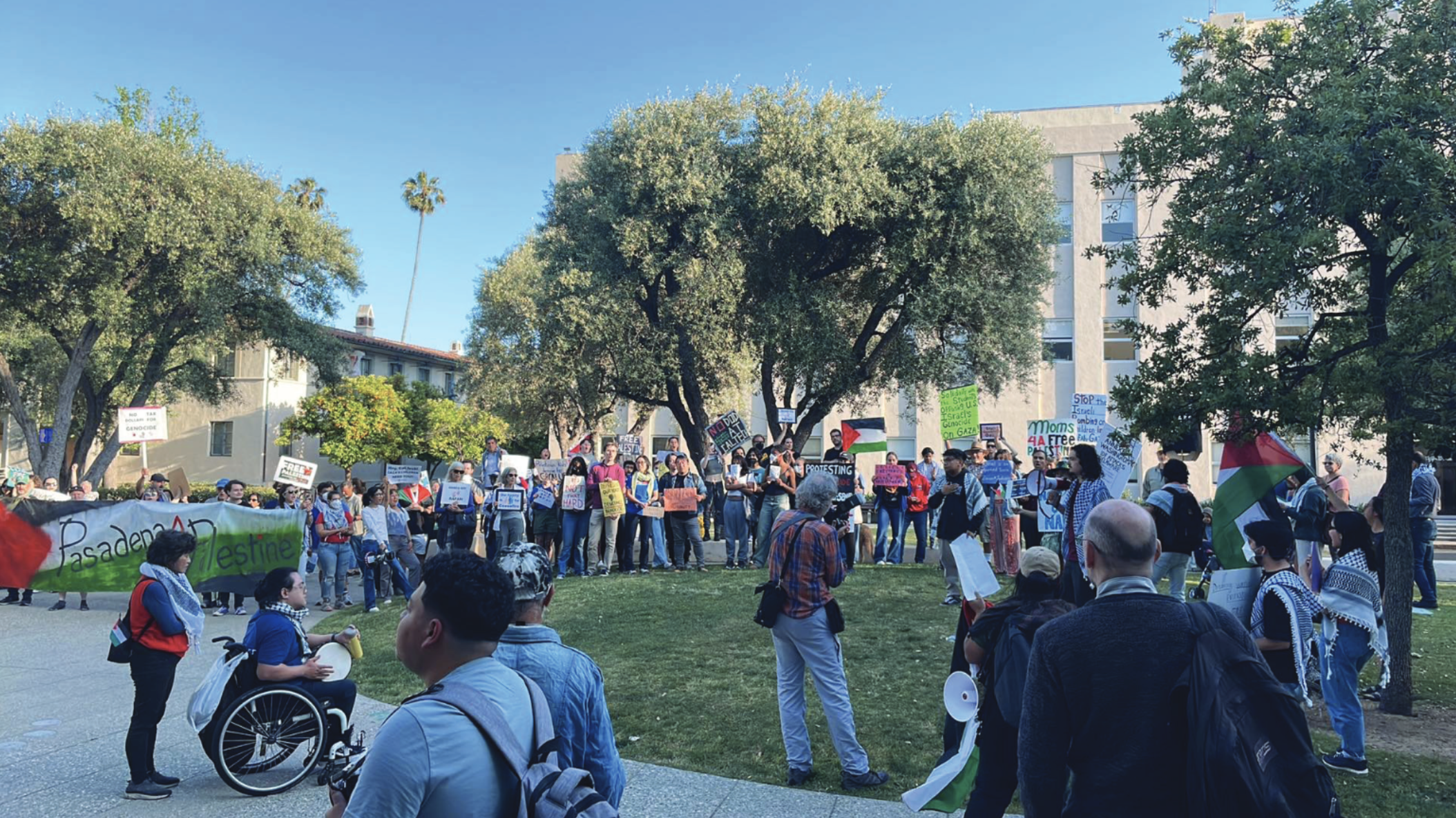 Another picture of the evening march; some people are holding a large banner in the colors of the Palestinian flag, with the words “Pasadena 4 Palestine” written on it