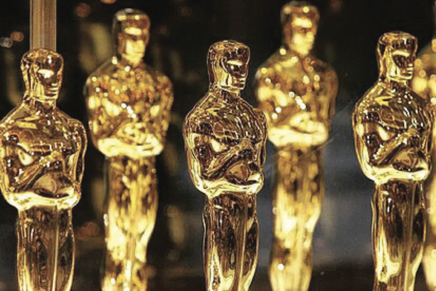 A row of gold Oscar statuettes